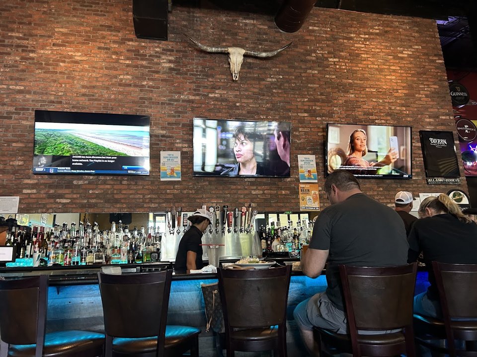 Sports bar interior with TVs and seating.